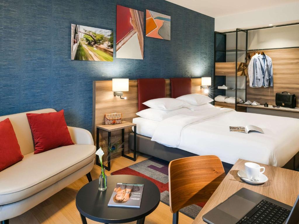 日內瓦的住宿－Mercure Geneva Airport，酒店客房,设有两张床和一张沙发