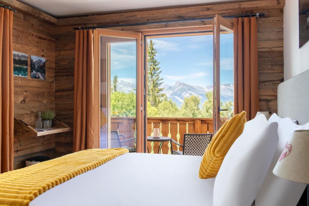 ein Schlafzimmer mit einem Bett und einem großen Fenster in der Unterkunft PAPILL'ON - Boutique Hotel in La Tzoumaz