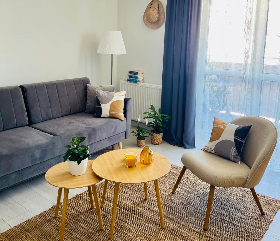 a living room with a couch and a table and chairs at BeeApartments Naściszowska 18 in Nowy Sącz