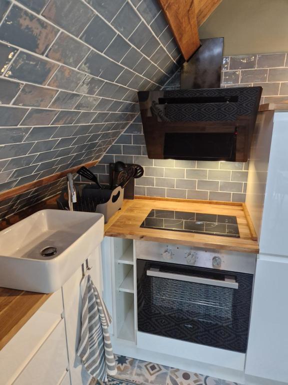 a kitchen with a sink and a stove at le perchoir a 500m des plages in Cancale