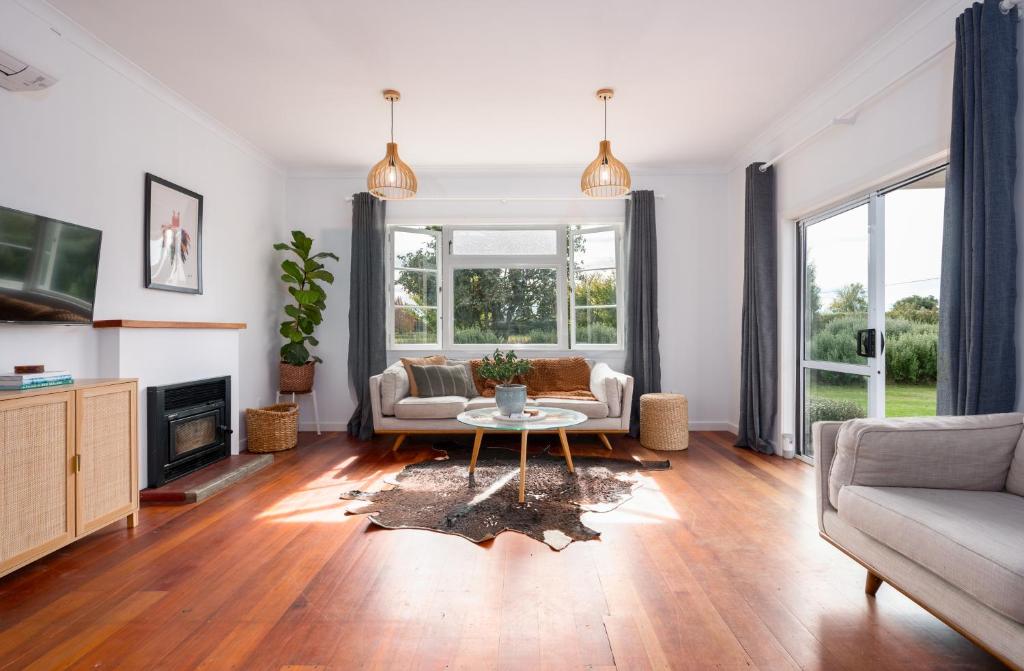 een woonkamer met een bank en een tafel bij The Blue House in Havelock North