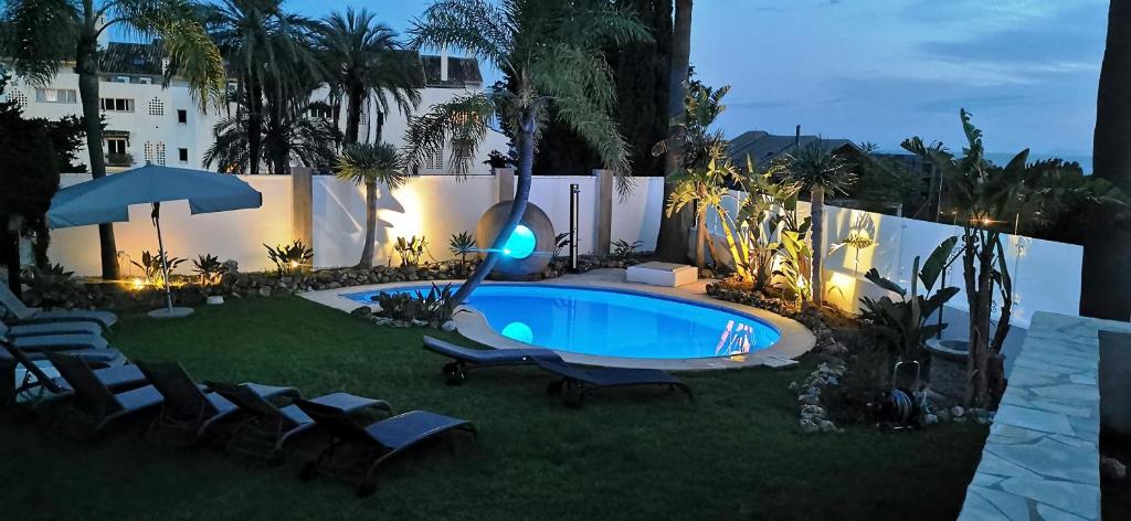 einen Hinterhof mit einem Pool mit Stühlen und einem Zaun in der Unterkunft Villa Jazz Marbella with 7 bedrooms in Marbella