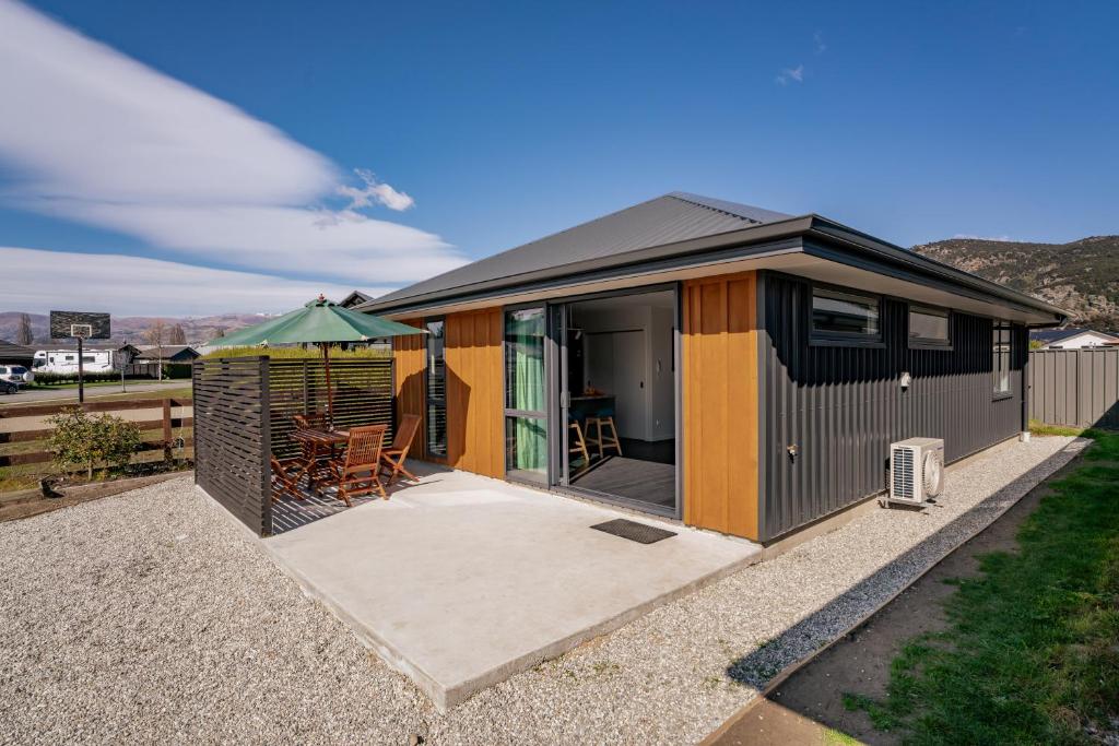a tiny house with a patio in a yard at Holiday in a paradise in Wanaka