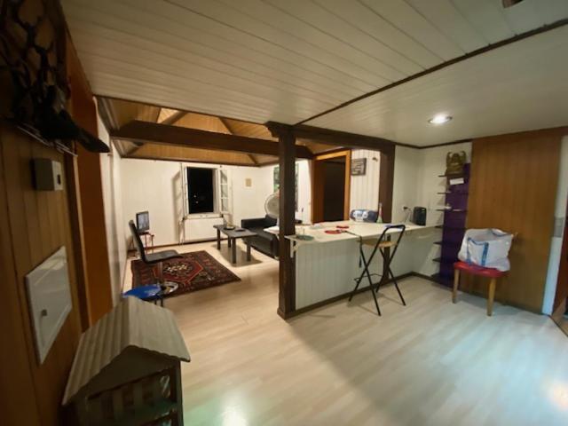 ein Wohnzimmer mit einer Küche und ein Wohnzimmer mit einem Tisch in der Unterkunft Sonderbar Home in Schwyz