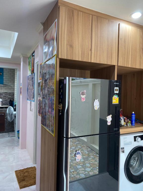a kitchen with a refrigerator with stickers on it at bom bomm home for lovery in Bangna