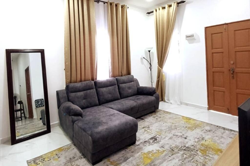 sala de estar con sofá y espejo en Singgah Homestay en Kuala Terengganu