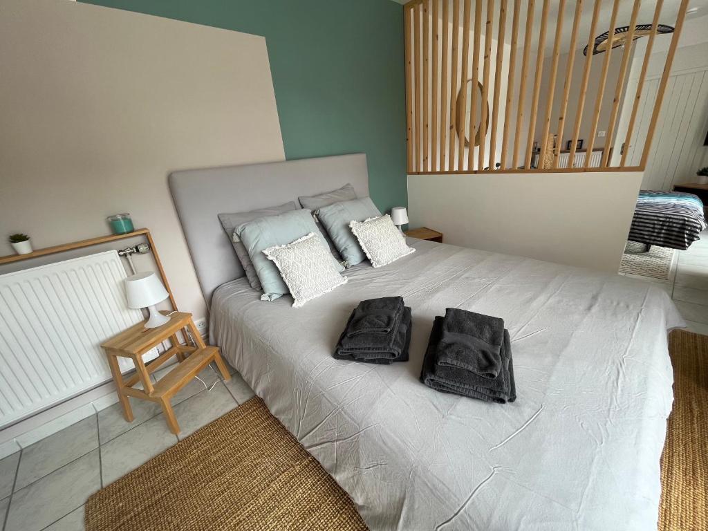 um quarto com uma cama com duas toalhas pretas em La Villa des Dards em Miribel