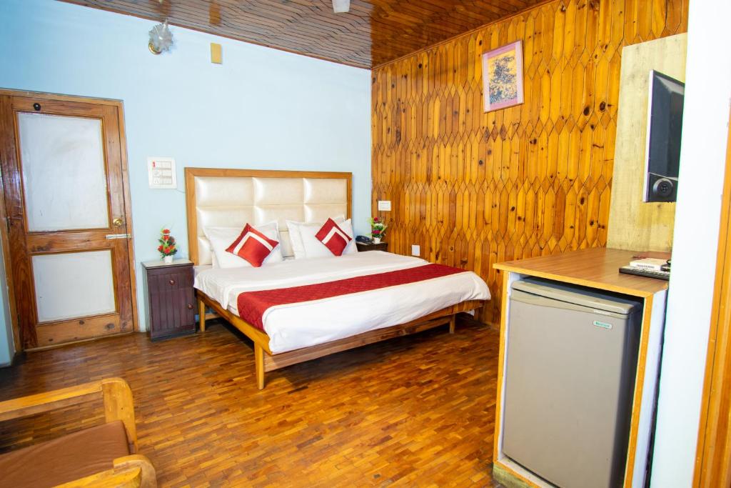 a bedroom with a bed and a television in it at Octave Himalayan Hamlet in Kulu