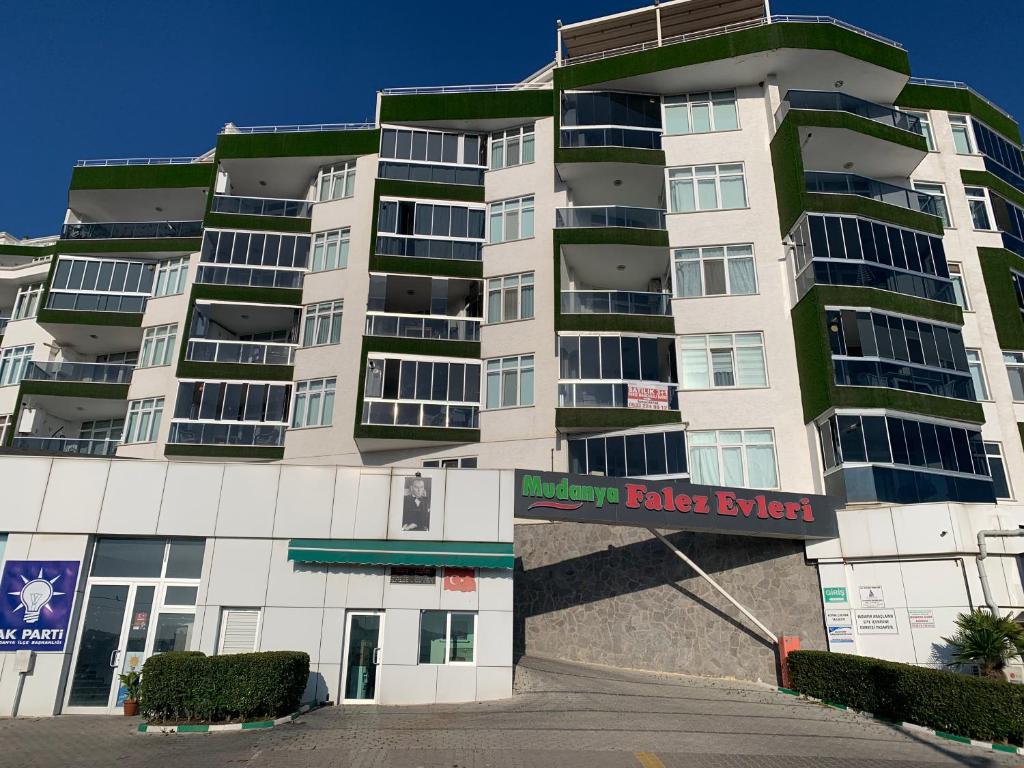 a tall white building with a dealer sign on it at Mudanya Falez Evleri. in Mudanya