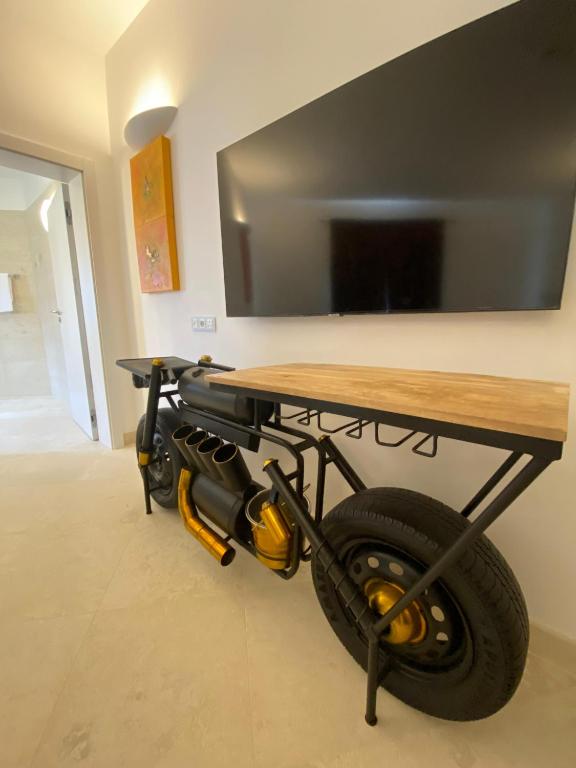 a table with a tv and a wheel under it at The White Knight Premium Boutique Hotel in Għajnsielem