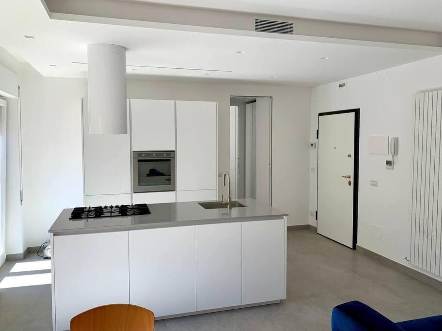 uma cozinha com armários brancos e um forno com placa de fogão em La Ritorna em Ortona