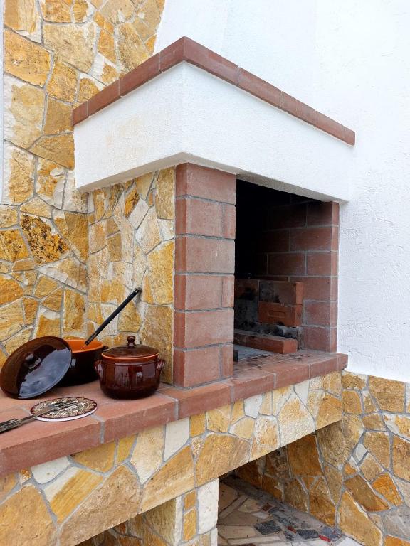 ceglany piec z garnkiem i patelniami w obiekcie Villa Luigi w mieście Torre Pali