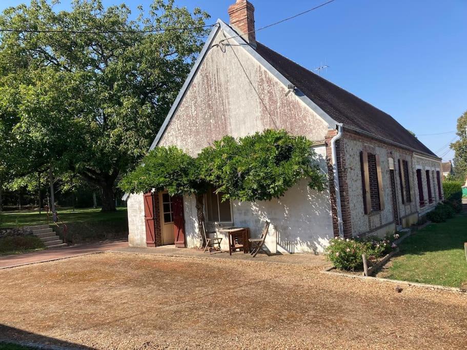 an old brick building with a red door at Longère du Perche in Montigny-le-Chartif