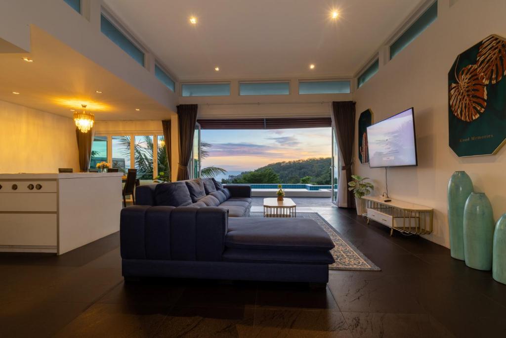 a living room with a couch and a tv at Cozy 5BR Villa Stunning SeaViews in Kamala Beach