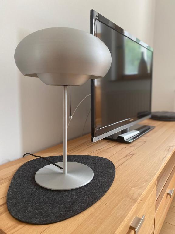 a white lamp sitting on a floor next to a tv at Ferienwohnung am Schölerberg in Osnabrück