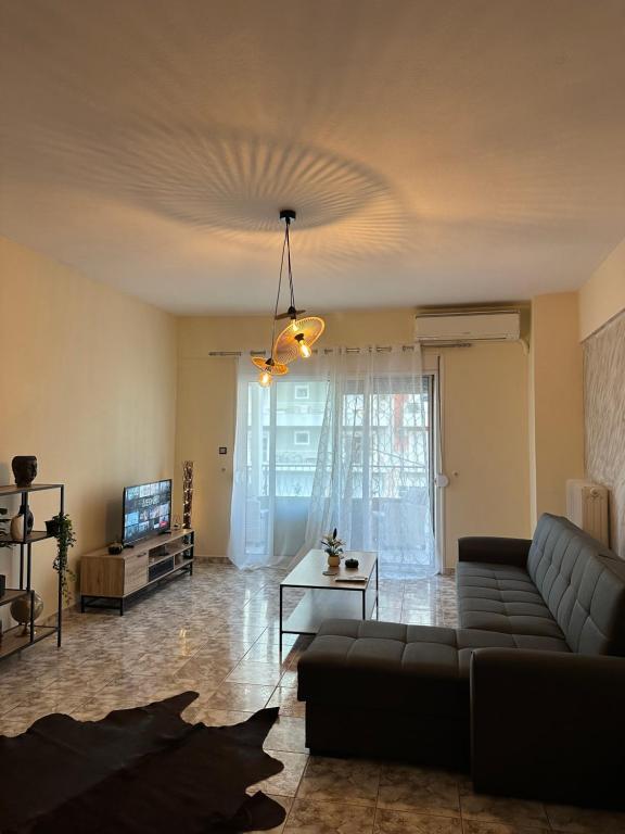 a living room with a couch and a tv at Άνετο διαμέρισμα - Κέντρο Ξάνθης in Xanthi
