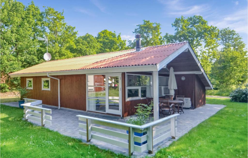 uma pequena cabina com um telhado inclinado em Awesome Home In Glesborg With Kitchen em Fjellerup Strand