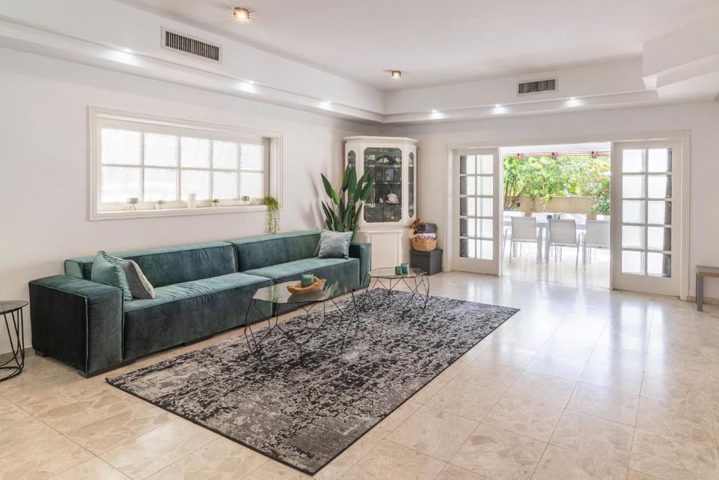 sala de estar con sofá verde y alfombra en Luxury Villa 6BR with Swimming Pool by Beach - Villa Costa, en Rishon LeZion