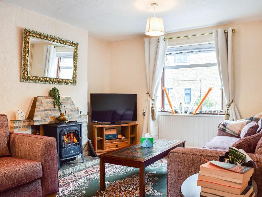 a living room with a fireplace and a tv at Sheldon House in Braunston