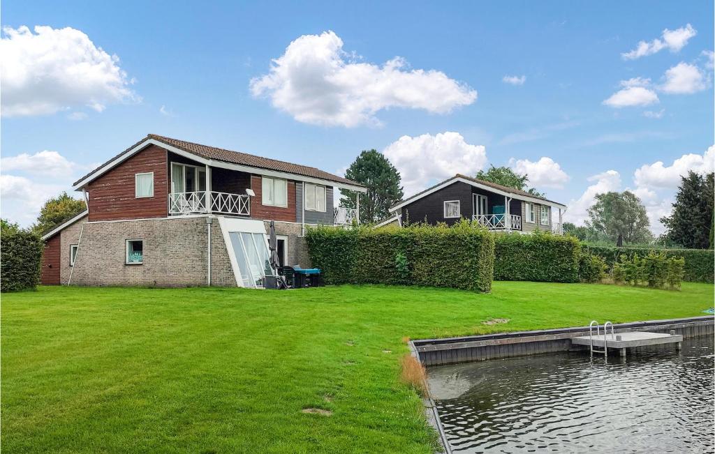 een grote tuin met een huis en een vijver bij Awesome Home In Vlagtwedde With Indoor Swimming Pool in Vlagtwedde