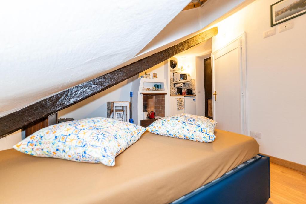 Bett mit Kissen darauf in einem Zimmer in der Unterkunft sotto i tetti di Torino mansarda di Gil in Turin