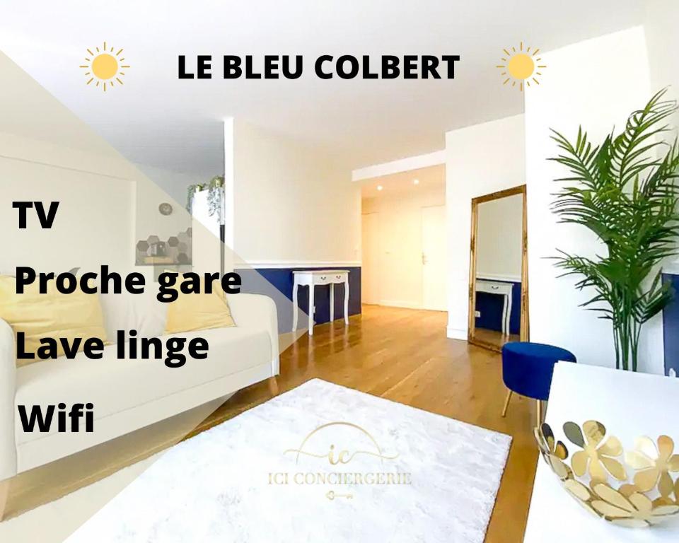 een woonkamer met een witte bank en een tafel bij Le Bleu Colbert in Versailles