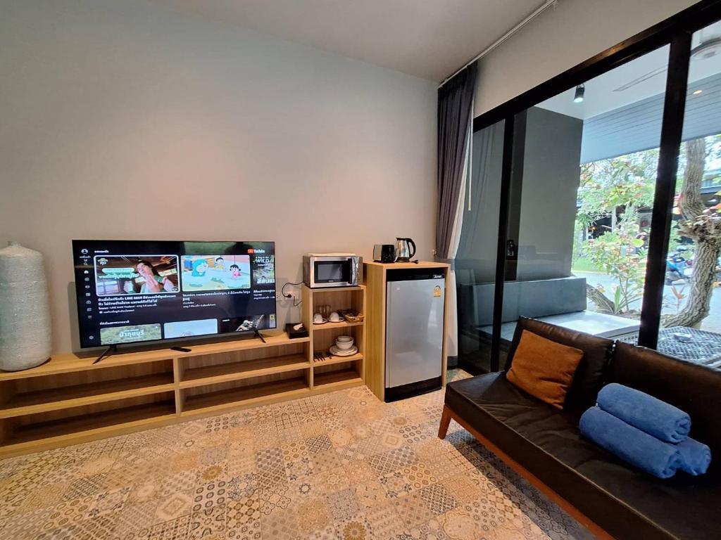 salon z telewizorem z płaskim ekranem i kanapą w obiekcie Seava House Ao-Nang Krabi w Aonang Beach