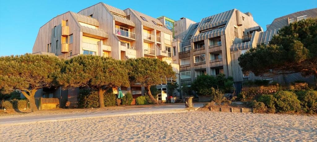 un grand bâtiment avec des arbres devant lui dans l'établissement Superbe appartement cosy - Plage des minimes, à La Rochelle