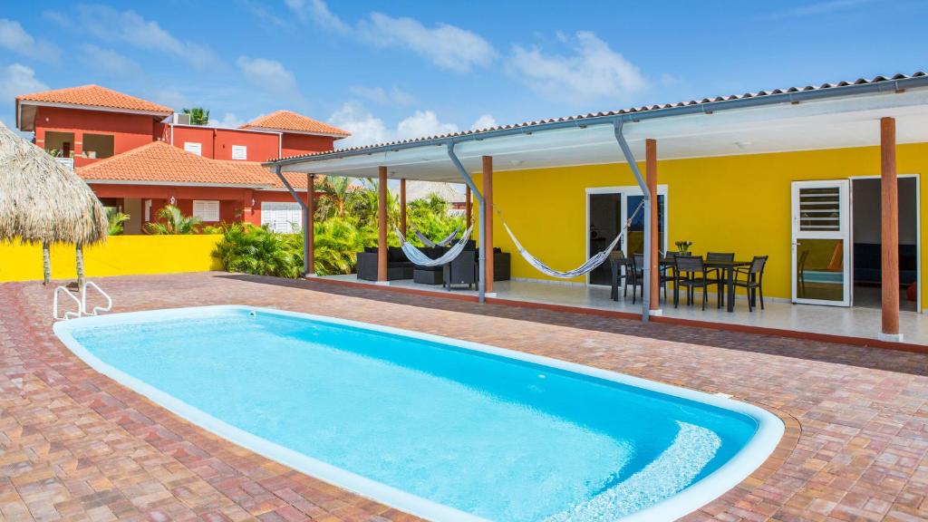 ein Pool vor einem Haus in der Unterkunft Finisterre Curaçao in Sabana Westpunt