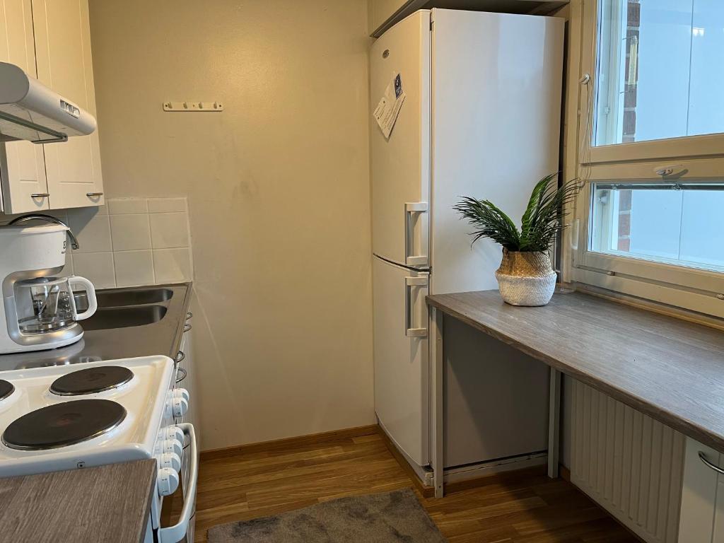 una cocina con nevera blanca y una planta en una encimera en Hilla Apartments en Rovaniemi