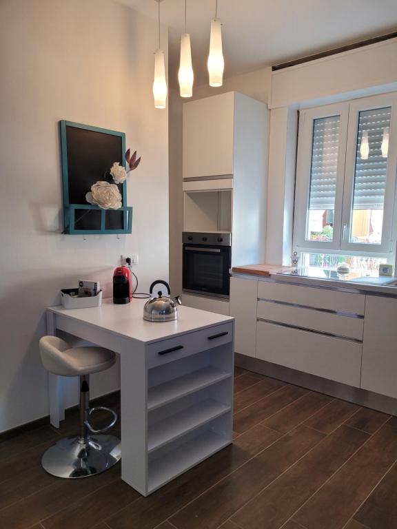 una cucina con bancone bianco e una scrivania con sgabello di santa maria al mare house a Rimini