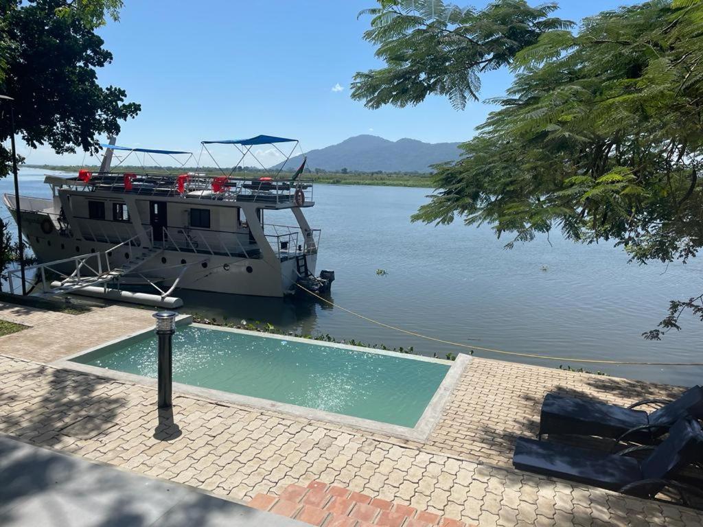 un barco está atracado en un río con un barco en Waters Edge Liwonde en Liwonde