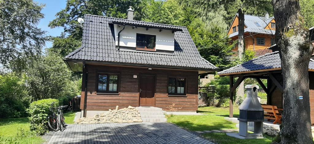 uma pequena casa de madeira com uma janela no topo em Chatička pod Lysou em Ostravice