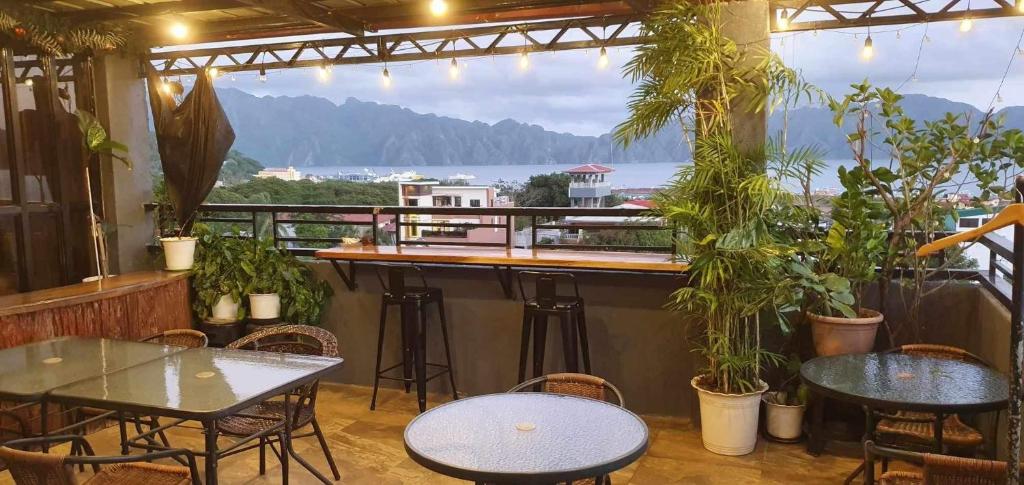 - un bar avec des tables et des chaises et une vue sur l'eau dans l'établissement Kalis Viewpoint Lodge Coron, à Coron