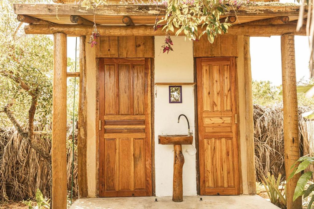 bagno con porta in legno e lavandino di Corumbau cura - Camping a Corumbau
