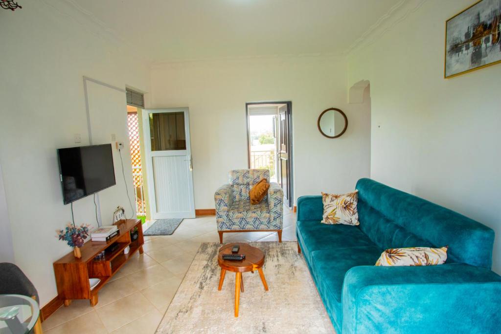 ein Wohnzimmer mit einem blauen Sofa und einem Tisch in der Unterkunft MANDJ STAYS in Seeta