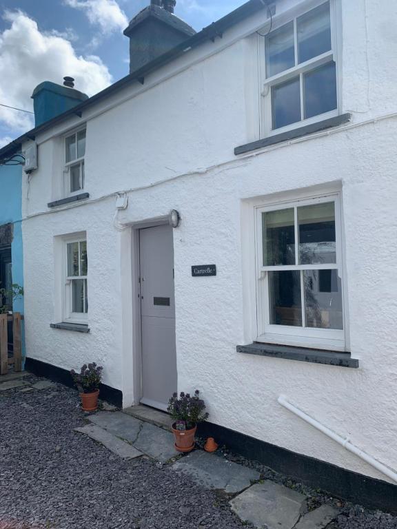 ein weißes Haus mit zwei Fenstern und einer Tür in der Unterkunft Character Cottage Nr Betws Y Coed. in Betws-y-coed