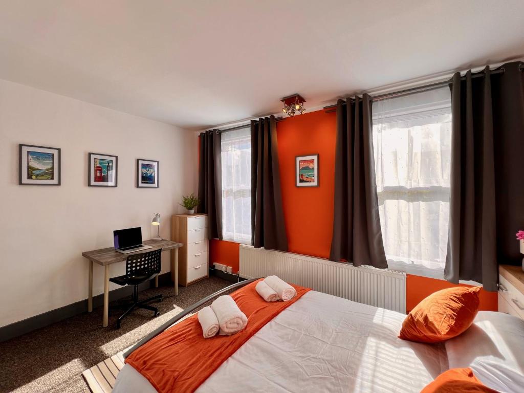 1 dormitorio con 1 cama y escritorio con ordenador en Clarence House 3 Bedrooms 8min to Station E17 North East London, en Londres
