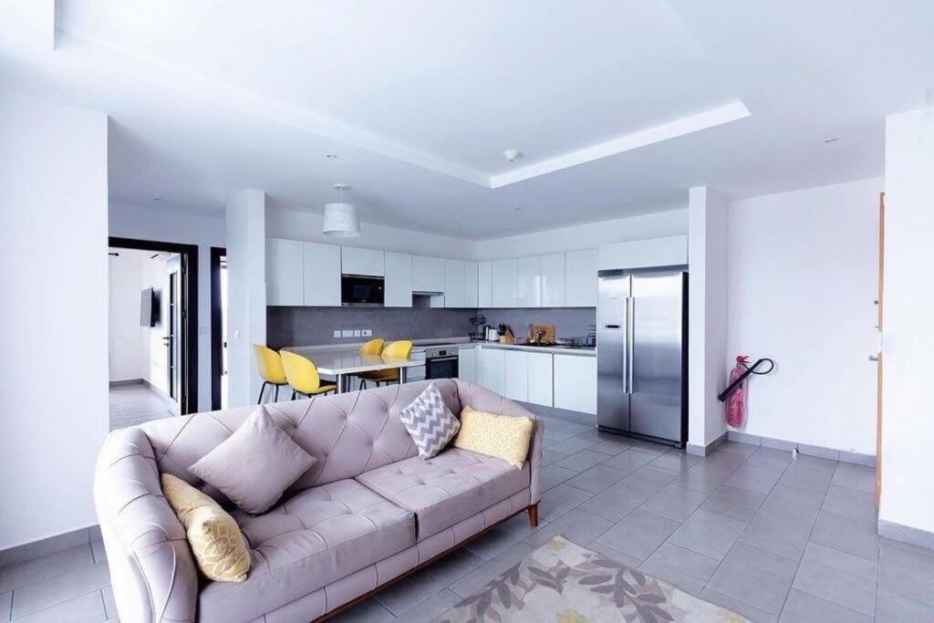 ein Wohnzimmer mit einem Sofa und einer Küche in der Unterkunft Labone Luxury Condo and Apartment in Accra - FiveHills homes in Accra