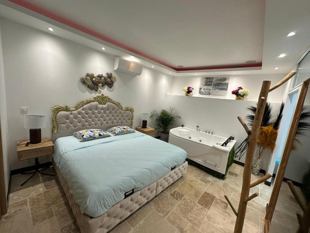 1 dormitorio con cama y bañera en L'Écrin de l'Amour en Saint-Avertin