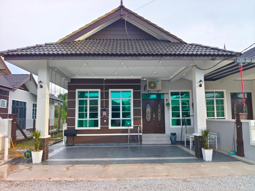 une maison avec une porte marron et des fenêtres vertes dans l'établissement Glamstay BatuRakit by Beach (Netflix,Umt,Unisza,Ipg), à Kuala Terengganu