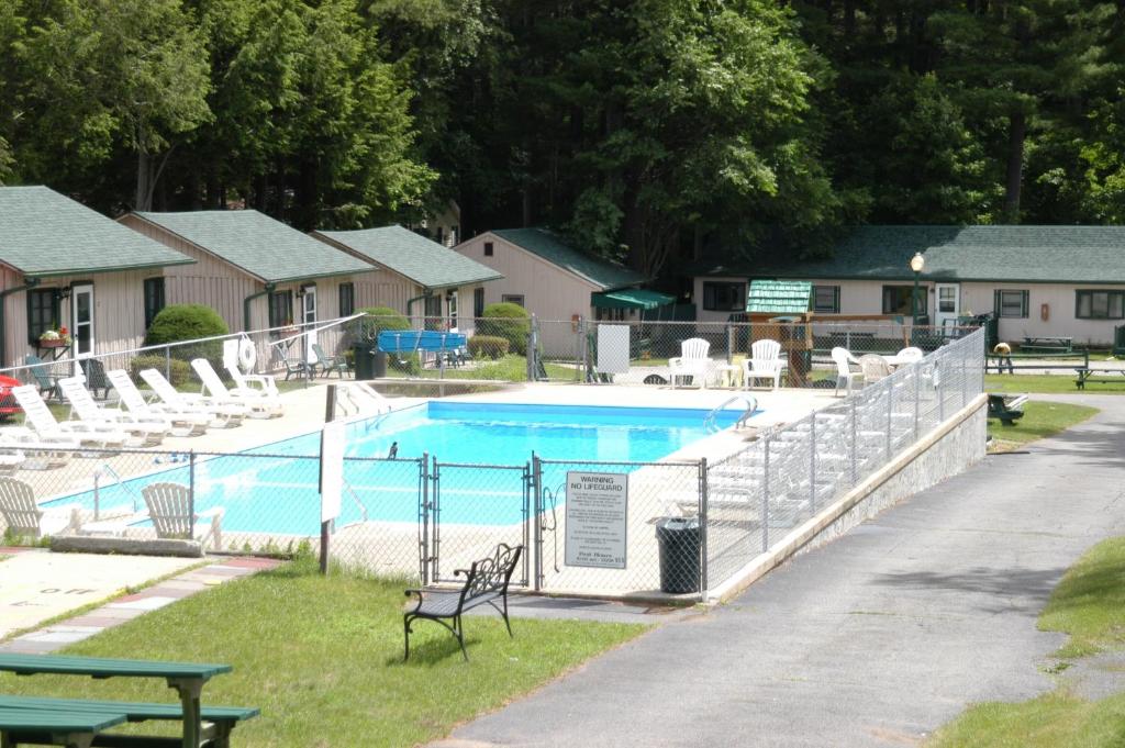 une clôture autour d'une piscine avec des chaises et une table dans l'établissement Lincoln Log Colony, à Lake George