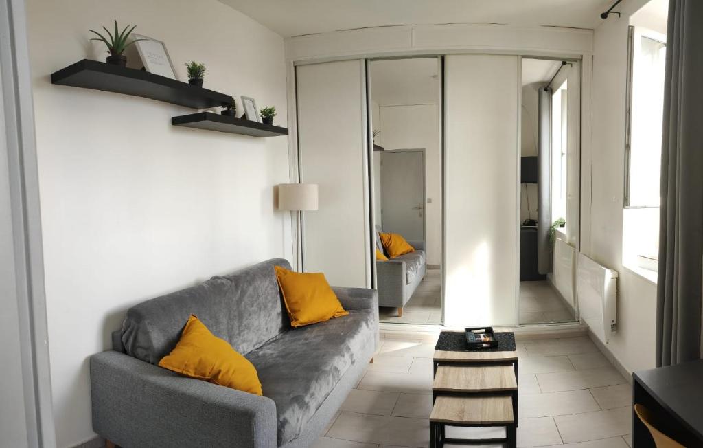 sala de estar con sofá gris y almohadas amarillas en Manoir - Studio - Fibre-wifi - Avon, en Avon