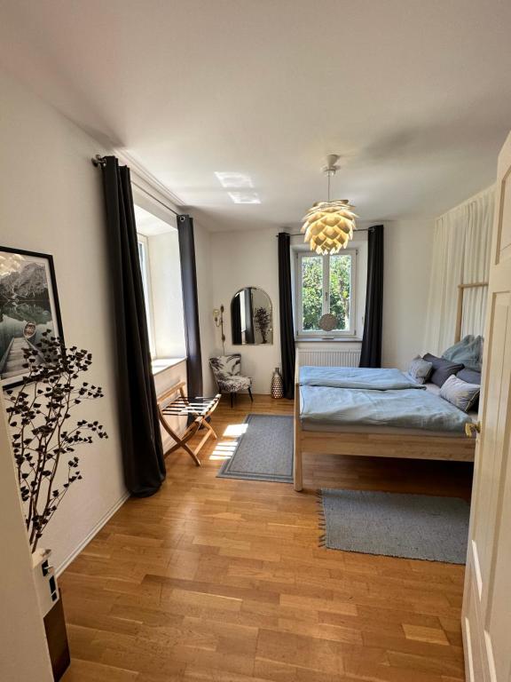 a bedroom with a bed and a chandelier at Villa Anton in Murnau am Staffelsee