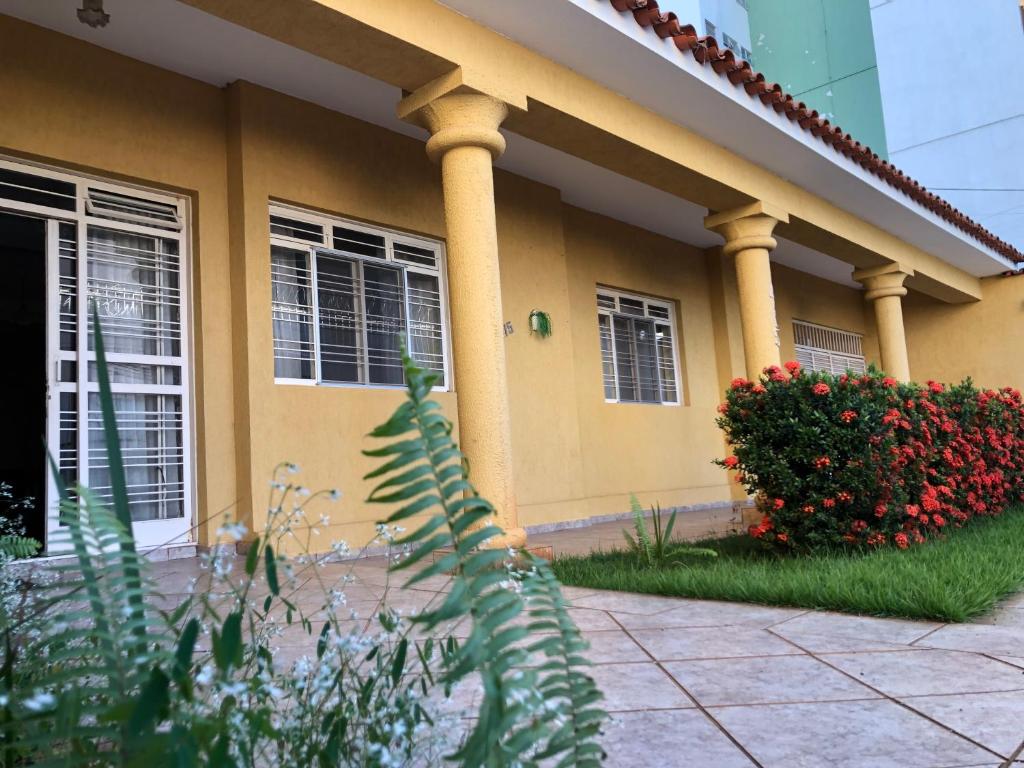 a house with columns and flowers in front of it at Hostel Vo Mariana in Goiânia