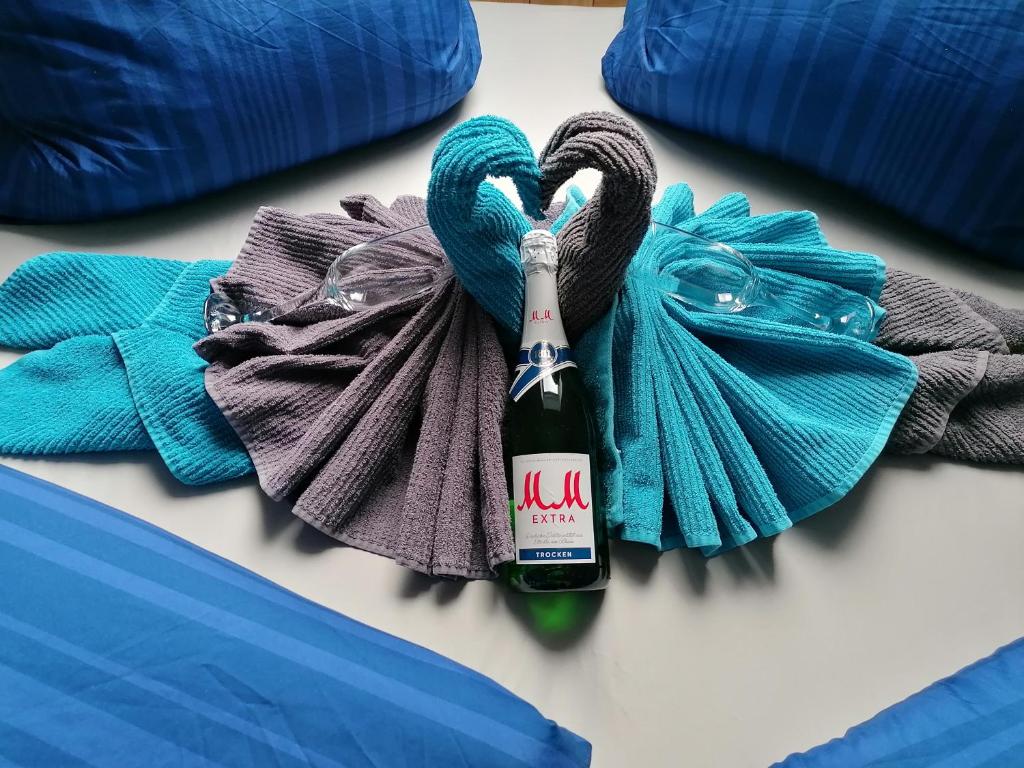 - Botella de champán en la cama con toalla en Ferienwohnung Little Joe, en Hötzelsroda