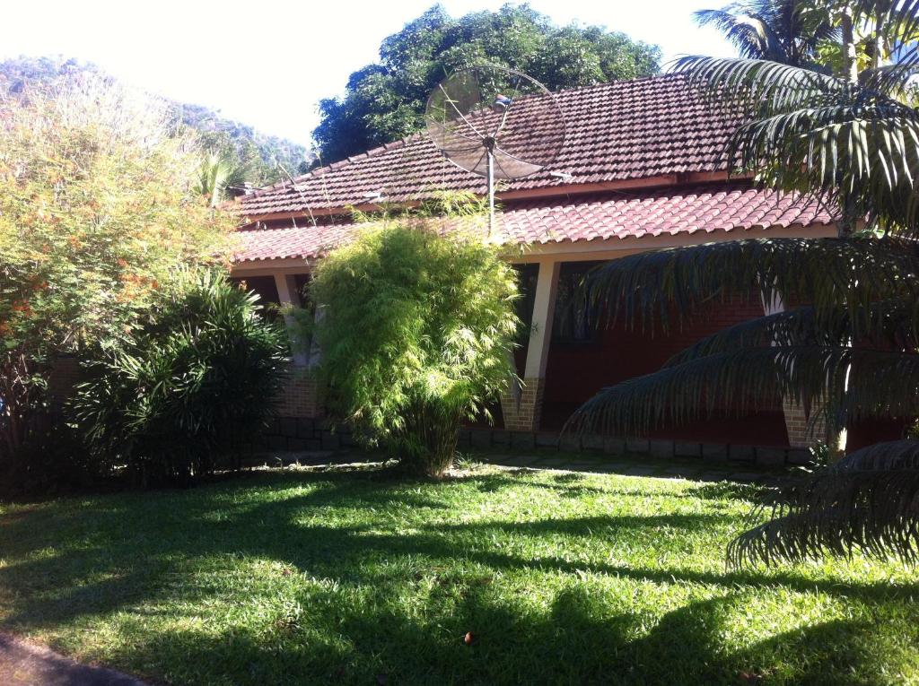 una casa con una palmera en el patio en Sítio dos Guedes, en Guapimirim