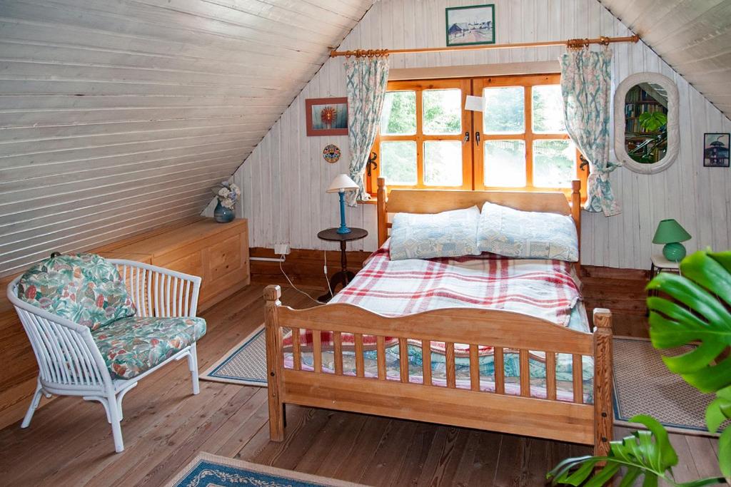 a bedroom with a bed and a chair in a attic at Kalinowa Chata in Wierchomla Wielka