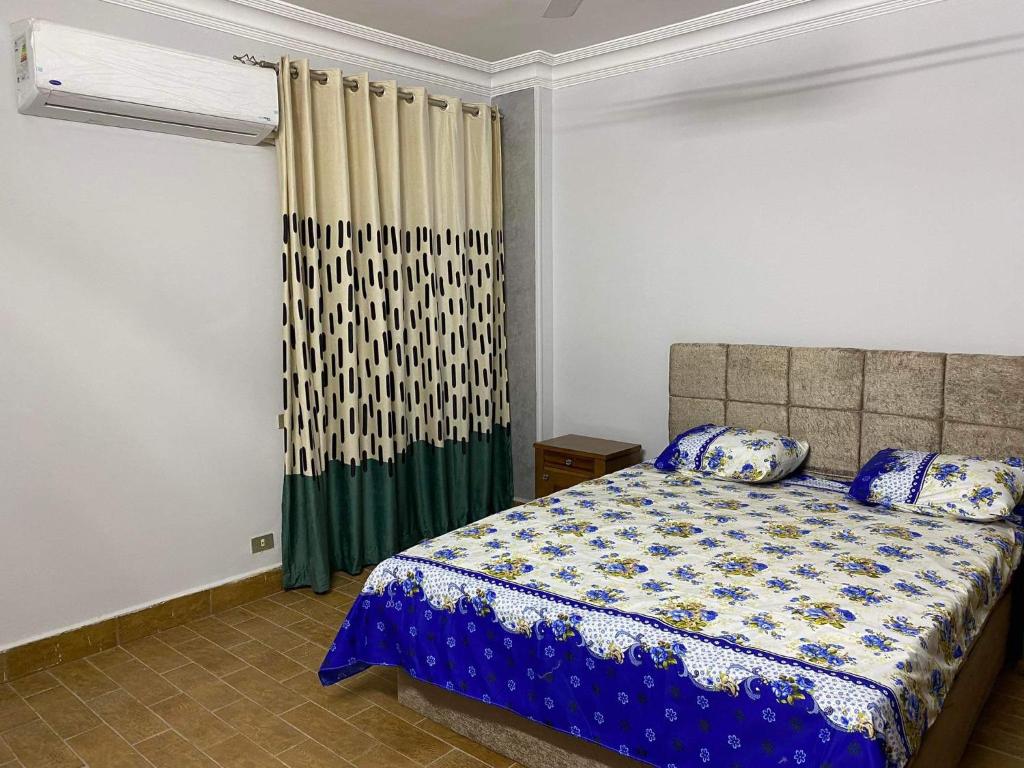 - une chambre avec un lit et une fenêtre avec des rideaux dans l'établissement شقة 9 شارع الصفاء / طه حسين / النزهة الجديدة, au Caire