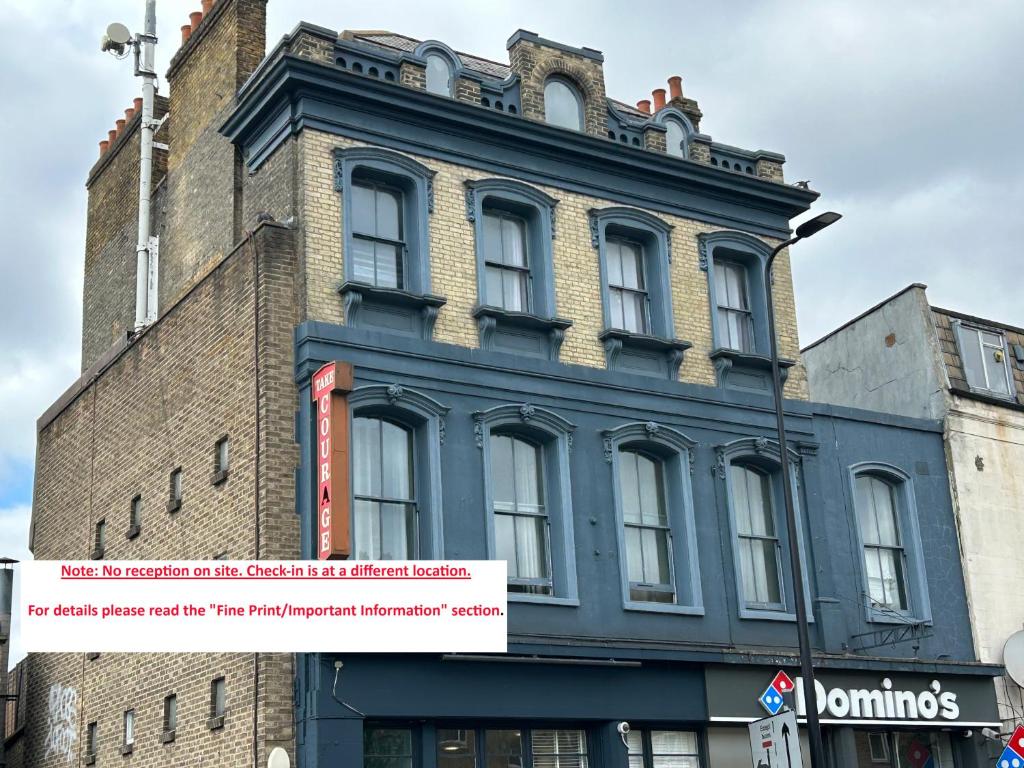 un edificio azul con un cartel en el costado en Cricketers Hostel, en Londres